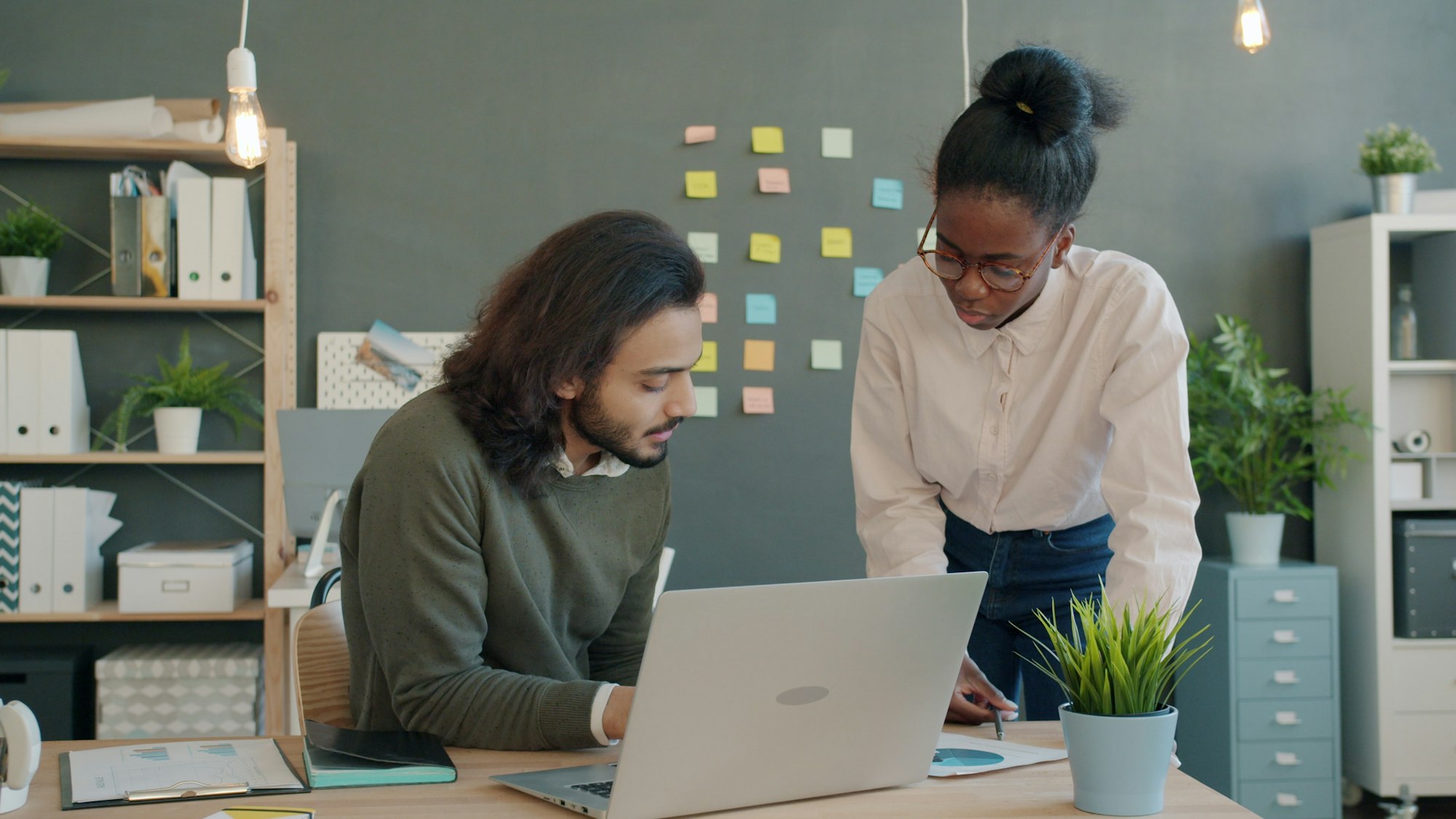Two colleagues reviewing work together on a laptop
